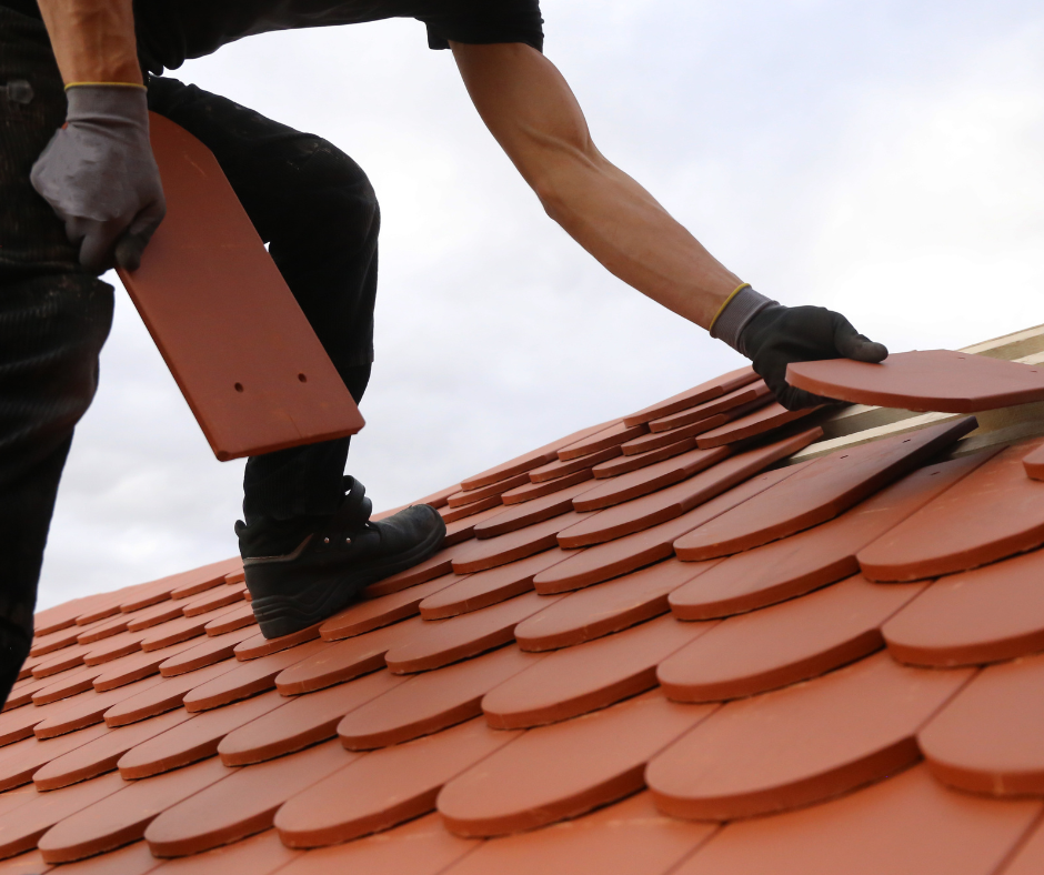 homme sur un toit installant des briques